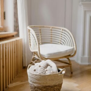 Bright and elegant Scandinavian-style living room featuring a wicker basket and chair.